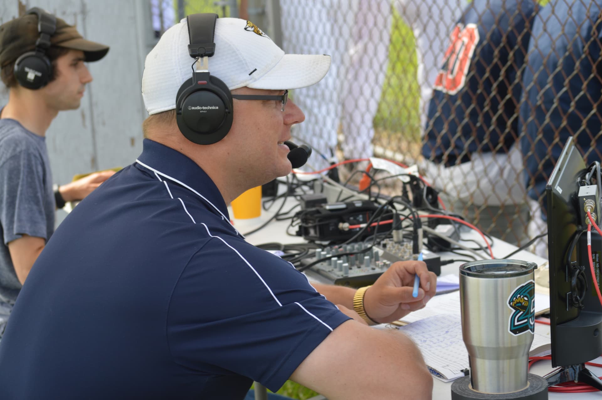 Tim Clagg calling a summer baseball game from an outdoor broadcast position