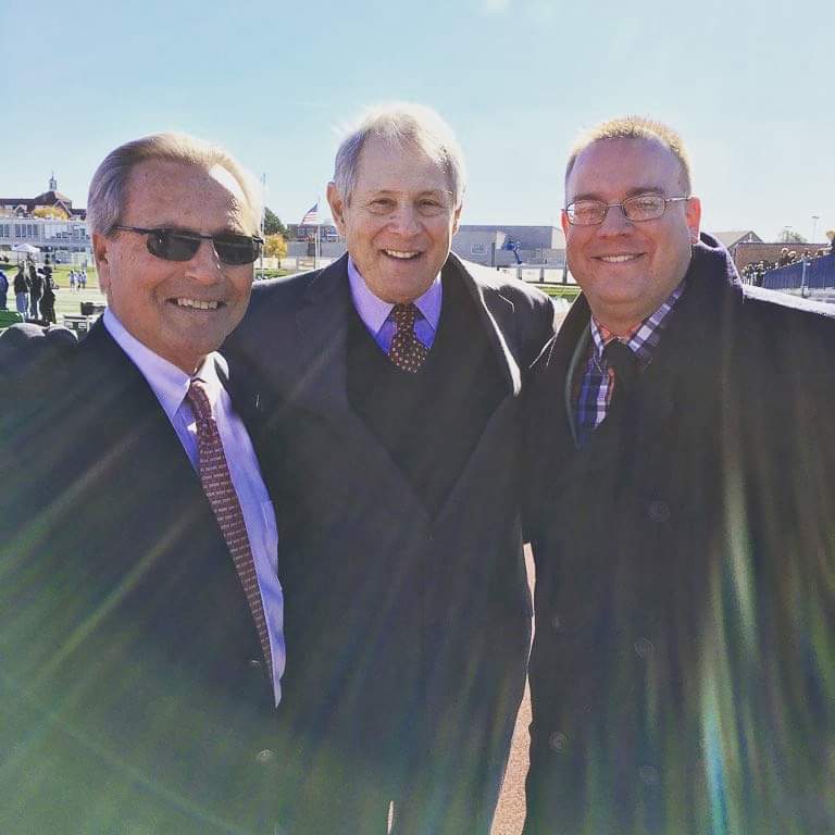 Tim Clagg with two fellow broadcasters outside a stadium on a sunny fall game day