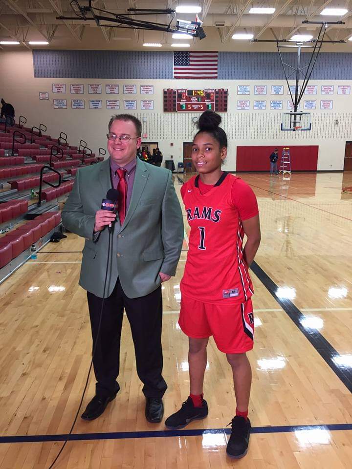 Tim Clagg interviewing a girls basketball player courtside with a BCSN microphone
