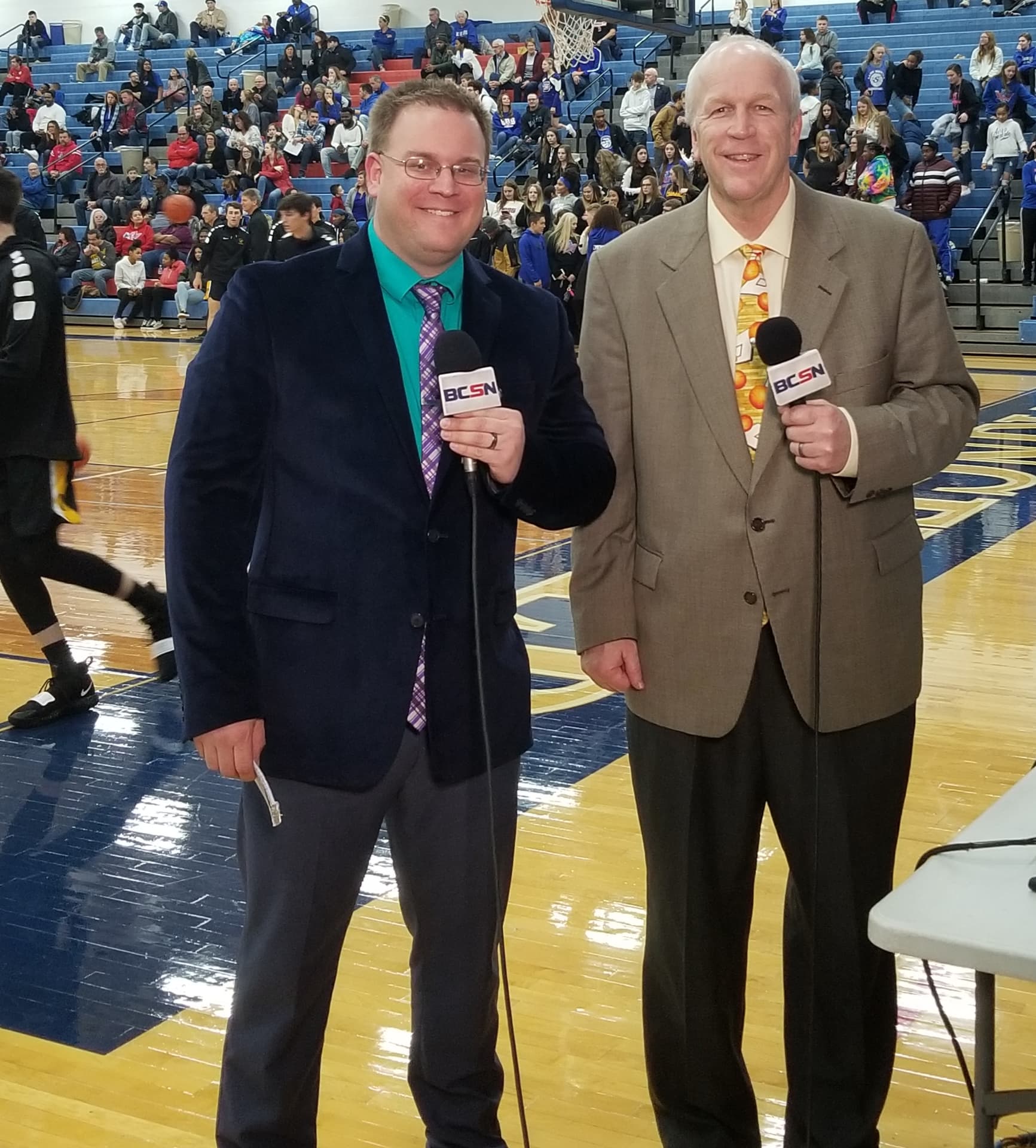 Tim Clagg courtside with a BCSN microphone before a high school basketball game