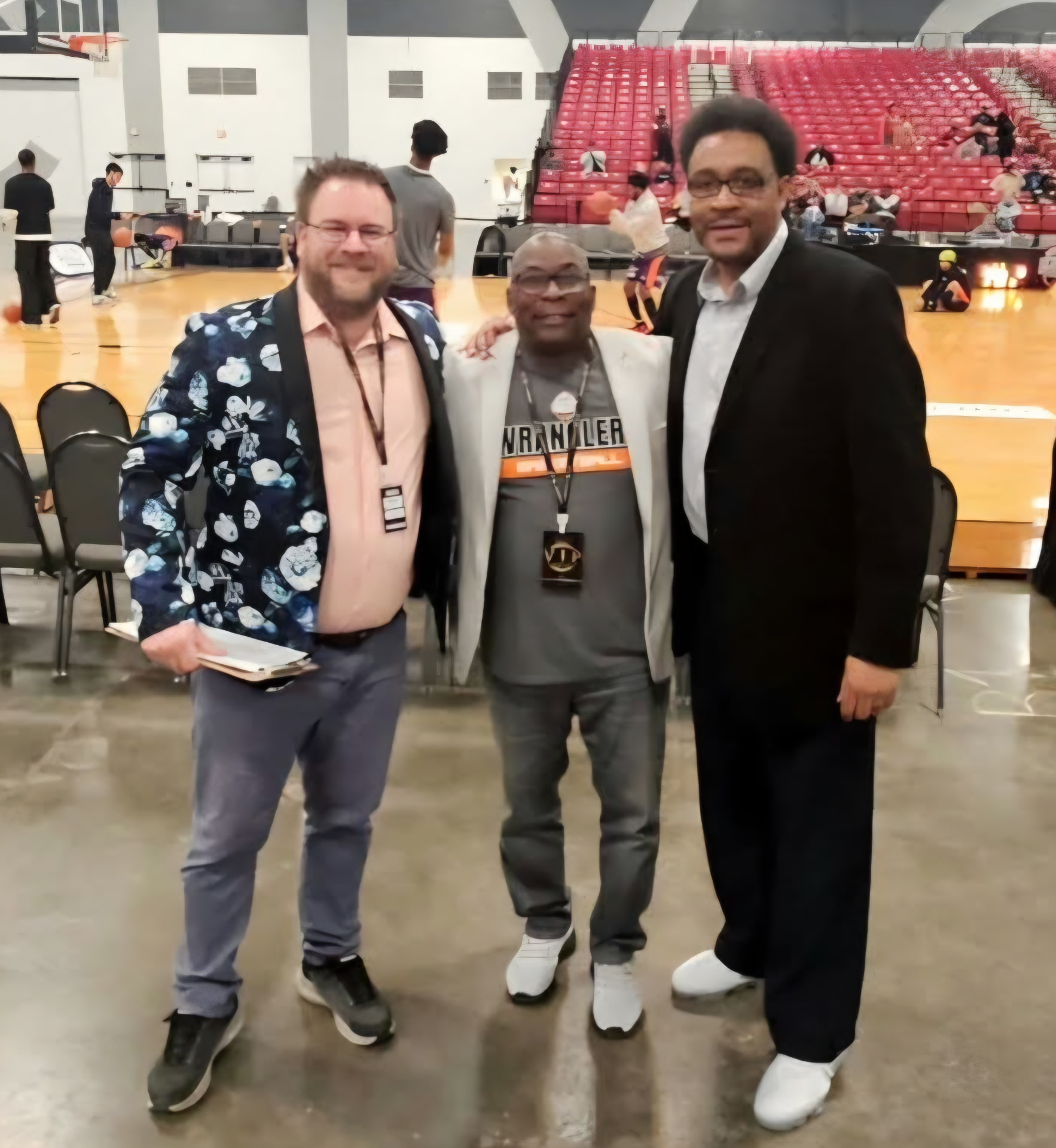 Tim Clagg with fellow broadcasters at a basketball tournament arena