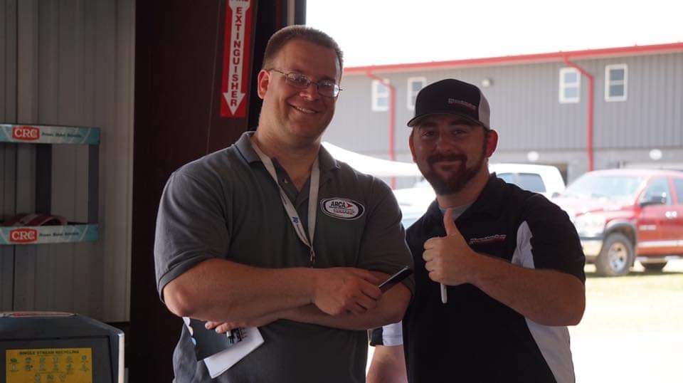 Tim Clagg in the garage area with a race team member during an ARCA event