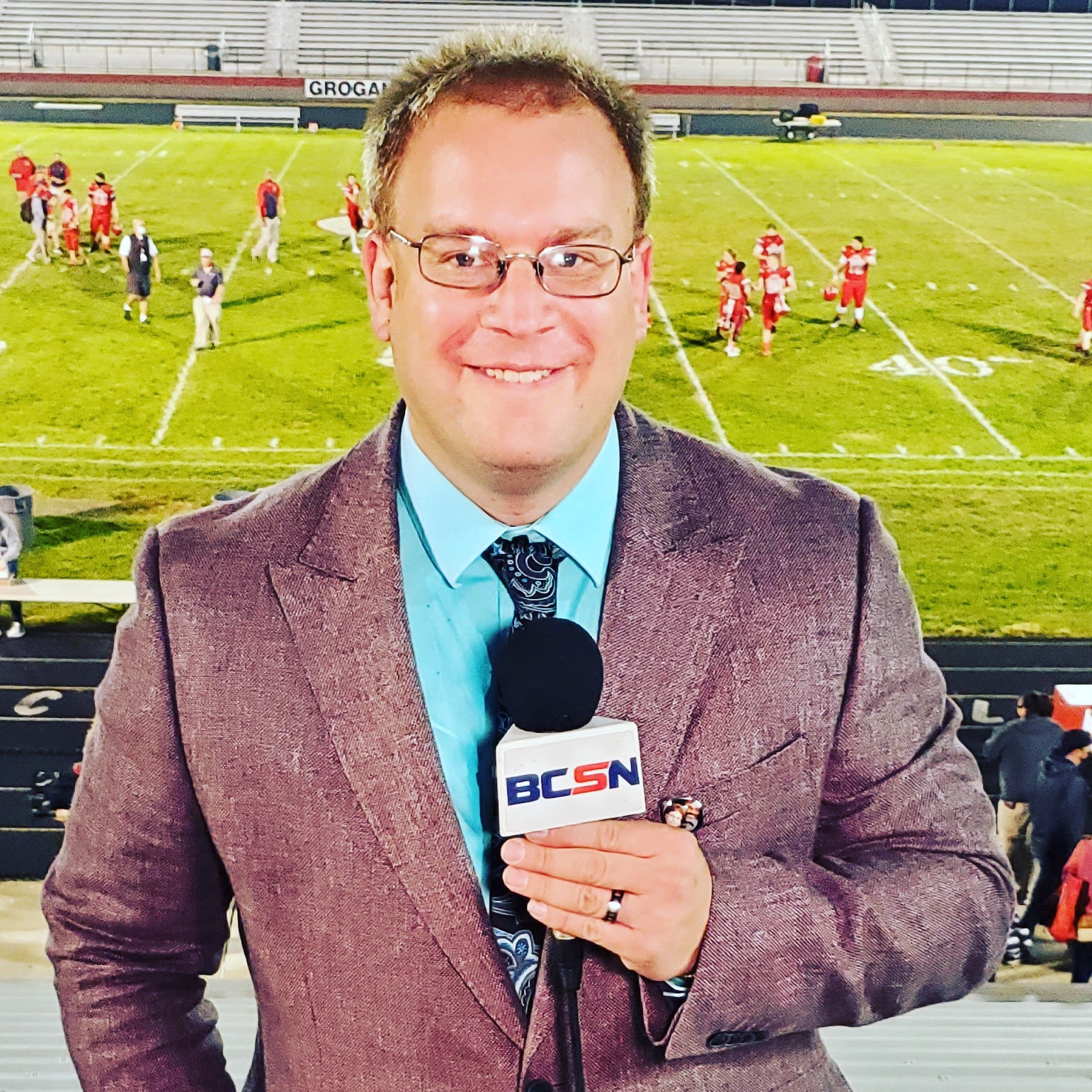 Tim Clagg with a BCSN microphone on the sideline of a Friday night high school football game